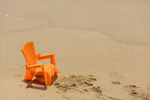 een plastieke strandstoel op een strand